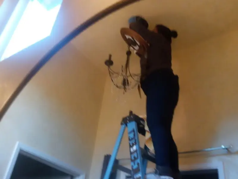 Electrician installing a chandelier in a Hamburg residence